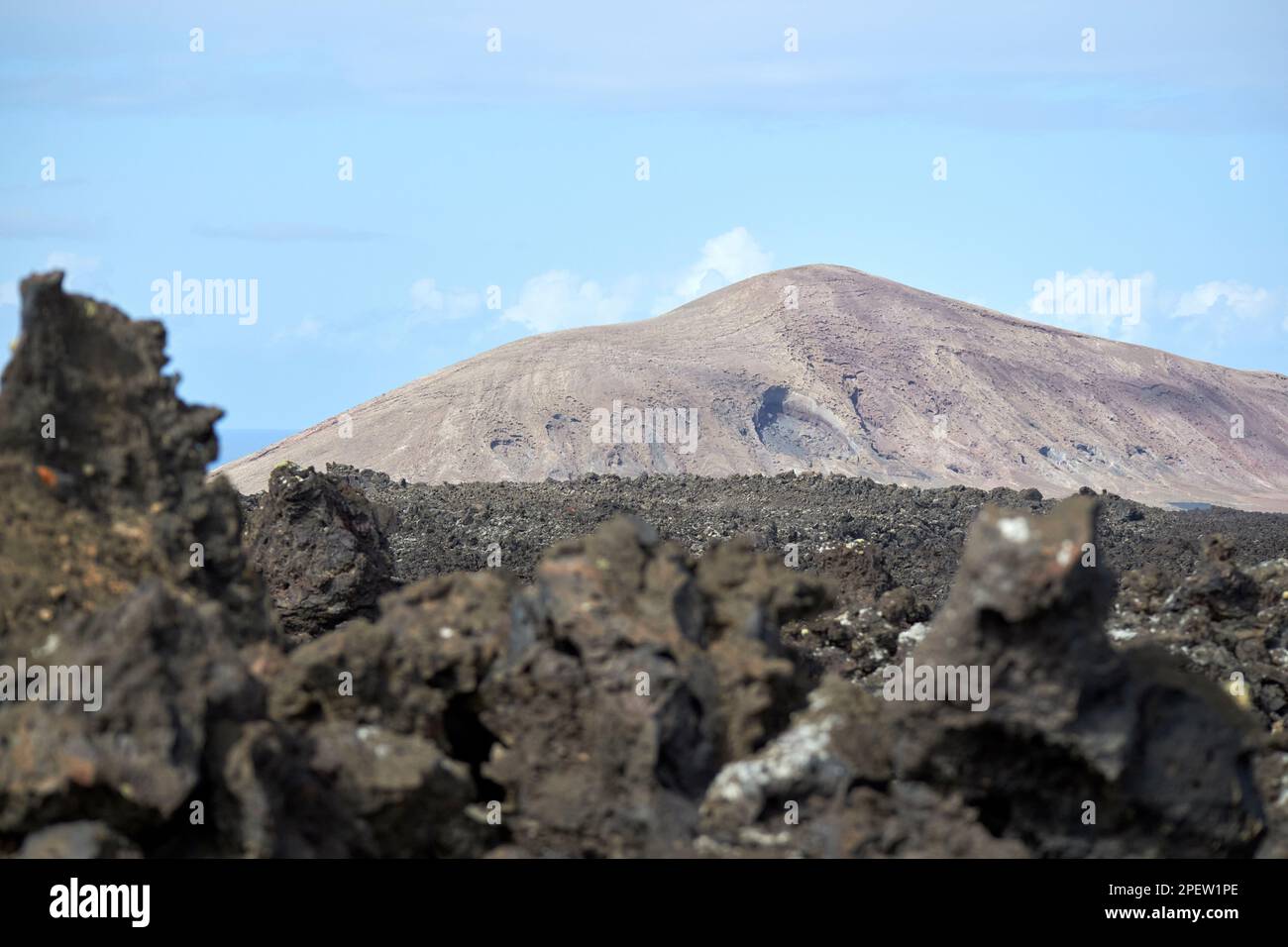 Blick über vulkanische Bomben, vulkanische Felsformationen und Lavafelder zu entfernten Vulkanen parque nacional de timanfaya Lanzarote, Kanarische Inseln, Spa Stockfoto