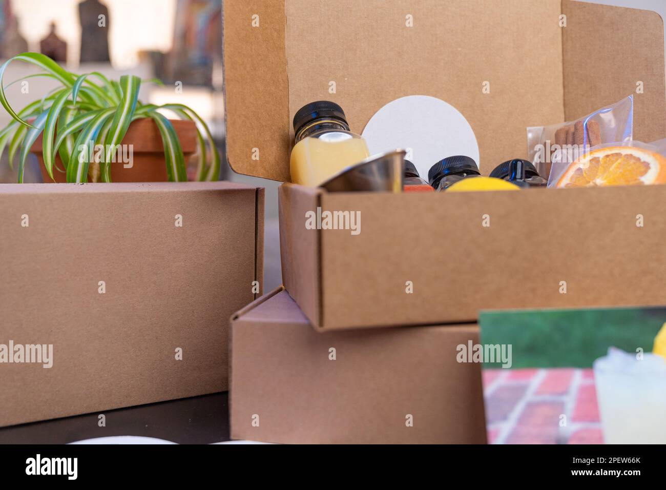 Drei Cocktailboxen zum Mitnehmen mit verschiedenen Zutaten für die Zubereitung alkoholischer Getränke (einschließlich Obst, Säfte und Sirup) Stockfoto