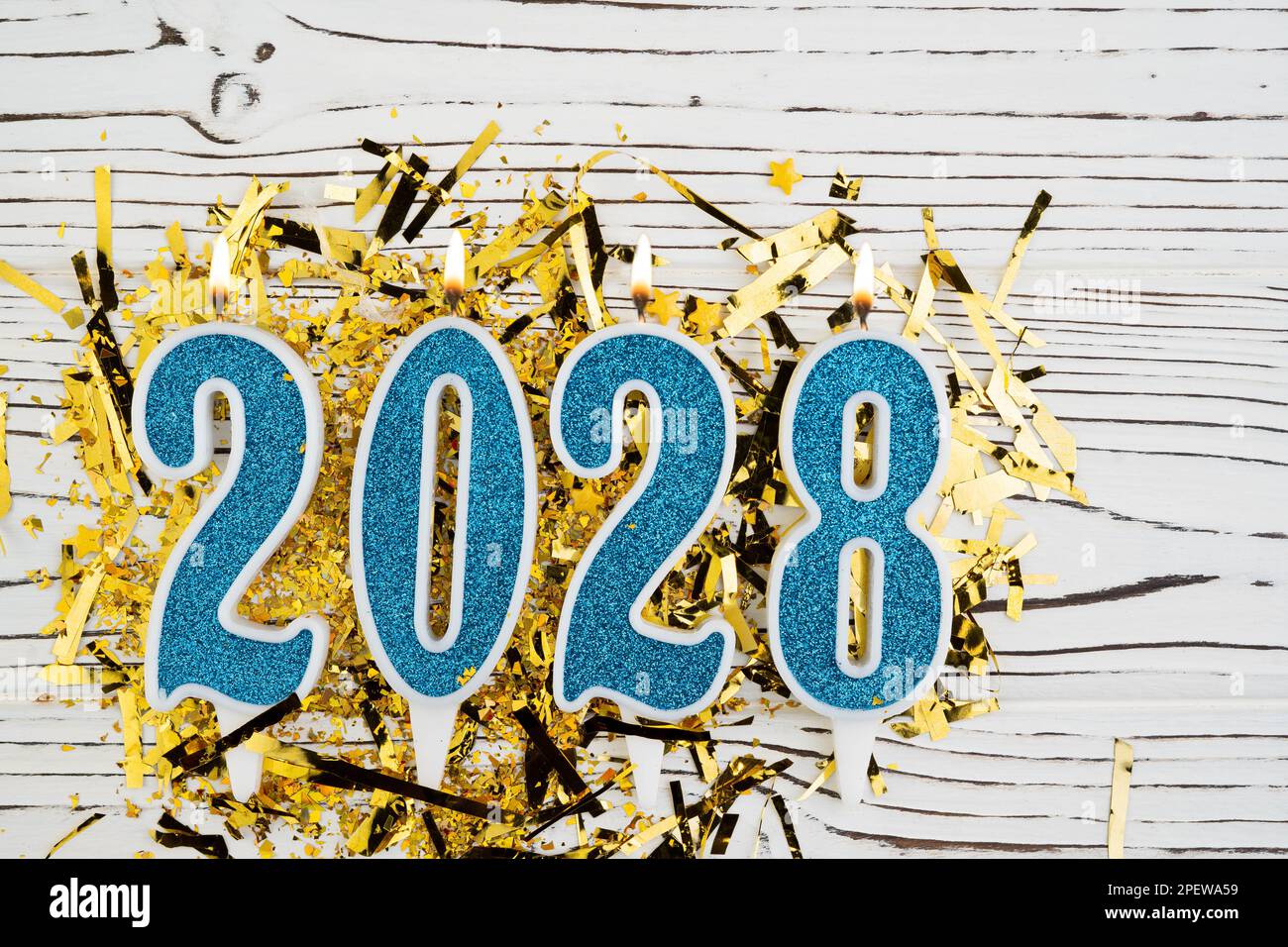 Feiertage Hintergrund Frohes neues Jahr 2028. Zahlen des Jahres 2028 aus blauen Kerzen auf festlichem weißem Holzhintergrund. Wir feiern Neujahrsfeiertage Stockfoto