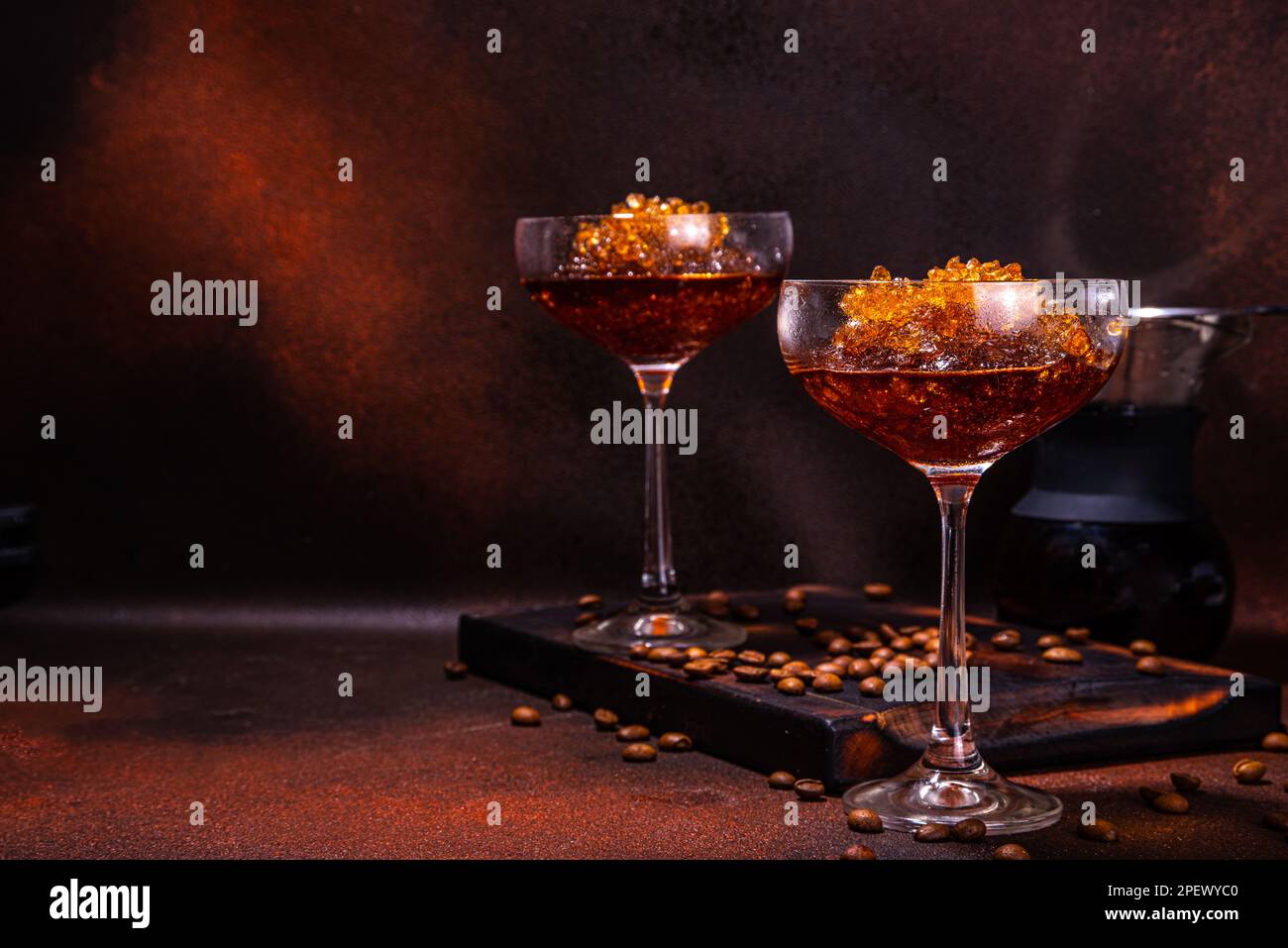 Espresso-Kaffee-Slush-Cocktail in martini-Glas, mit handgefertigter Kaffeepadmaschine. Harter Kaffee Granita, auf dunkelbraunem Hintergrund Kopierbereich Stockfoto