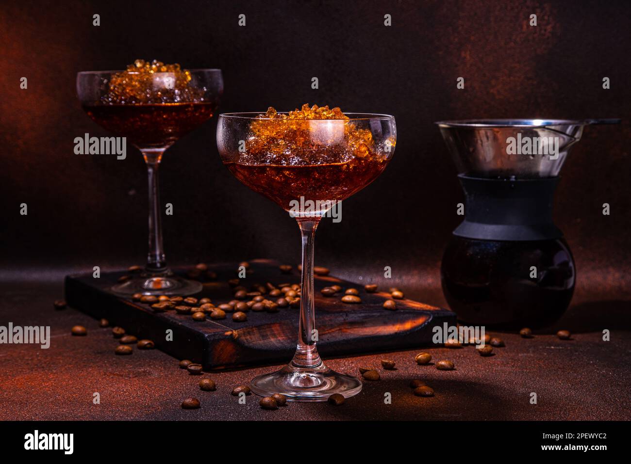 Espresso-Kaffee-Slush-Cocktail in martini-Glas, mit handgefertigter Kaffeepadmaschine. Harter Kaffee Granita, auf dunkelbraunem Hintergrund Kopierbereich Stockfoto