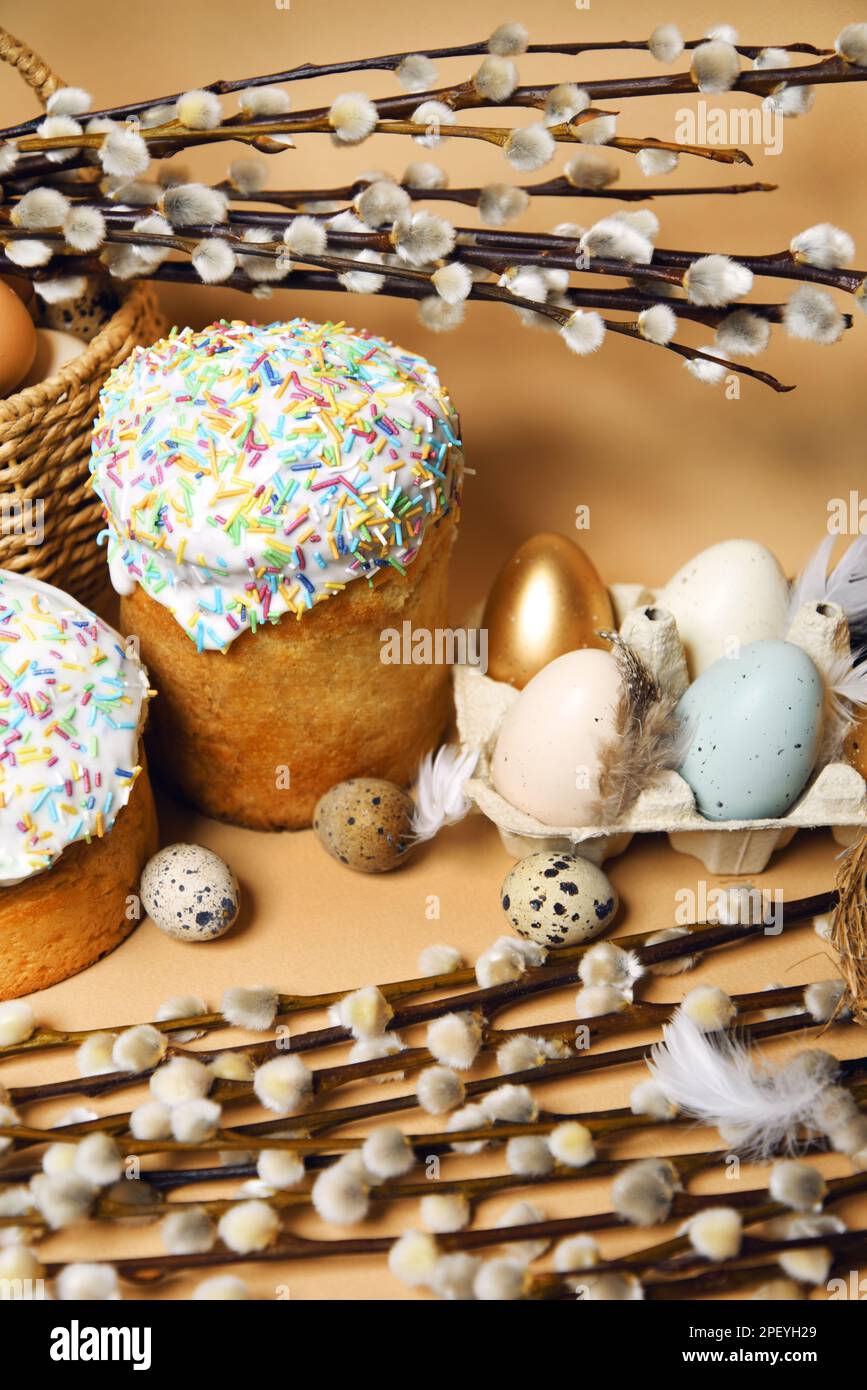 Osterferien, Muschi-Weide, bunte bemalte Eier in einem Tablett, Wachteleier in einem Nest, ein Korb mit Osterkuchen auf nacktem Hintergrund, warm. Religion A Stockfoto