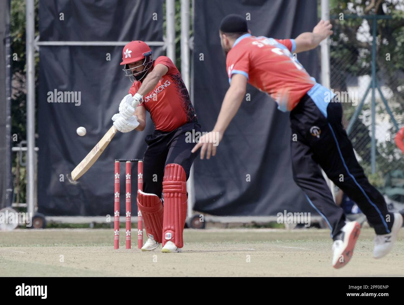 Hong Kong Cricket T20-Turnier zwischen Kuwait (rot/blau) und Hong Kong (rot/schwarz), auf dem Tin Kwong Recreation Ground in Ma Tau Wai. Batting ist Babar Hayat (L) in Hongkong, und Bowling ist Kuwaits Sayed Monib Sayed Ahmad (R). März 23 SCMP/Jonathan Wong Stockfoto