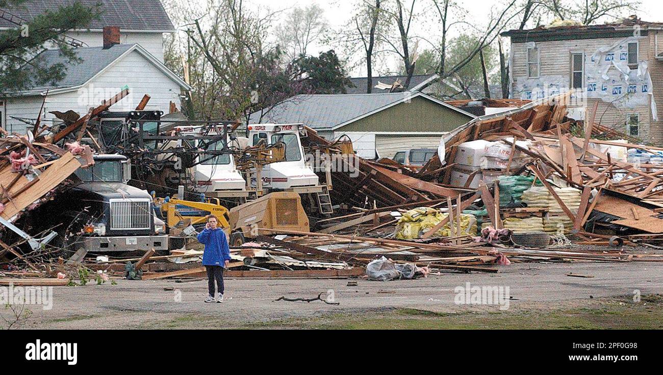 A resident ot Utica, Ill., talks on her cell phone near the Utica Grain elevator Tuesday, April 20, 2004, after a tornado tore through the downtown area. Severe storms spawning tornadoes cut a swath through Illinois and Indiana Tuesday, damaging scores of buildings and injuring at least six people, authorities said. Four of the injuries were in Illinois and two in Indiana, authorities said. (AP Photo/The Daily Times, Tom Sistak) Stockfoto