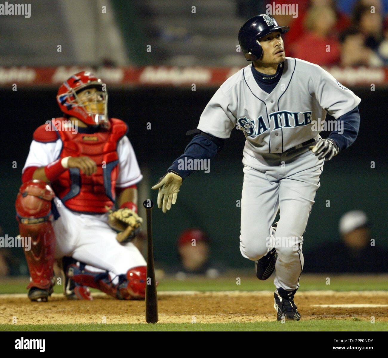 Seattle Mariners' Ichiro Suzuki of Japan, right, watches his double to center as Anaheim Angels catcher Jose Molina looks on during the ninth inning, Wednesday, April 14, 2004, in Anaheim, Calif. (AP Photo/Chris Carlson) Stockfoto
