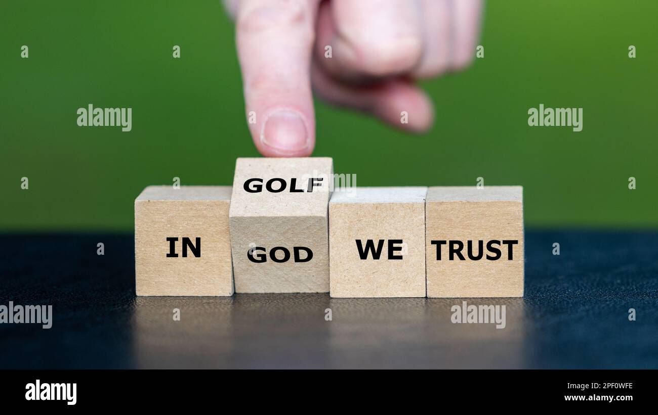 Die Hand dreht den Würfel und ändert den Satz „in gott vertrauen wir“ in „in Golf vertrauen wir“. Stockfoto