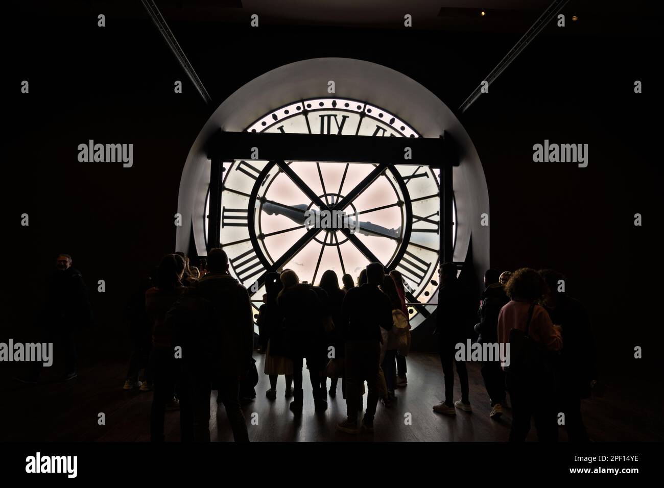Kleine Touristenmassen versammeln sich, um den Blick auf Paris durch das Museum der Orsay-Uhr zu genießen Stockfoto