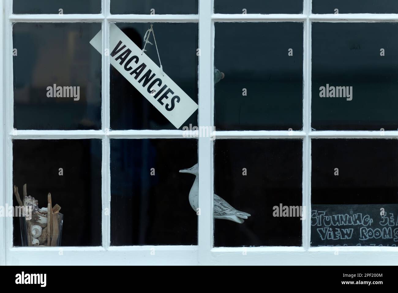 Ein "Wir haben freie Zimmer" -Schild hängt vor dem Fenster eines britischen Ferienhauses am Meer. Übernachtung mit Frühstück oder Kurzurlaub Let's Stockfoto