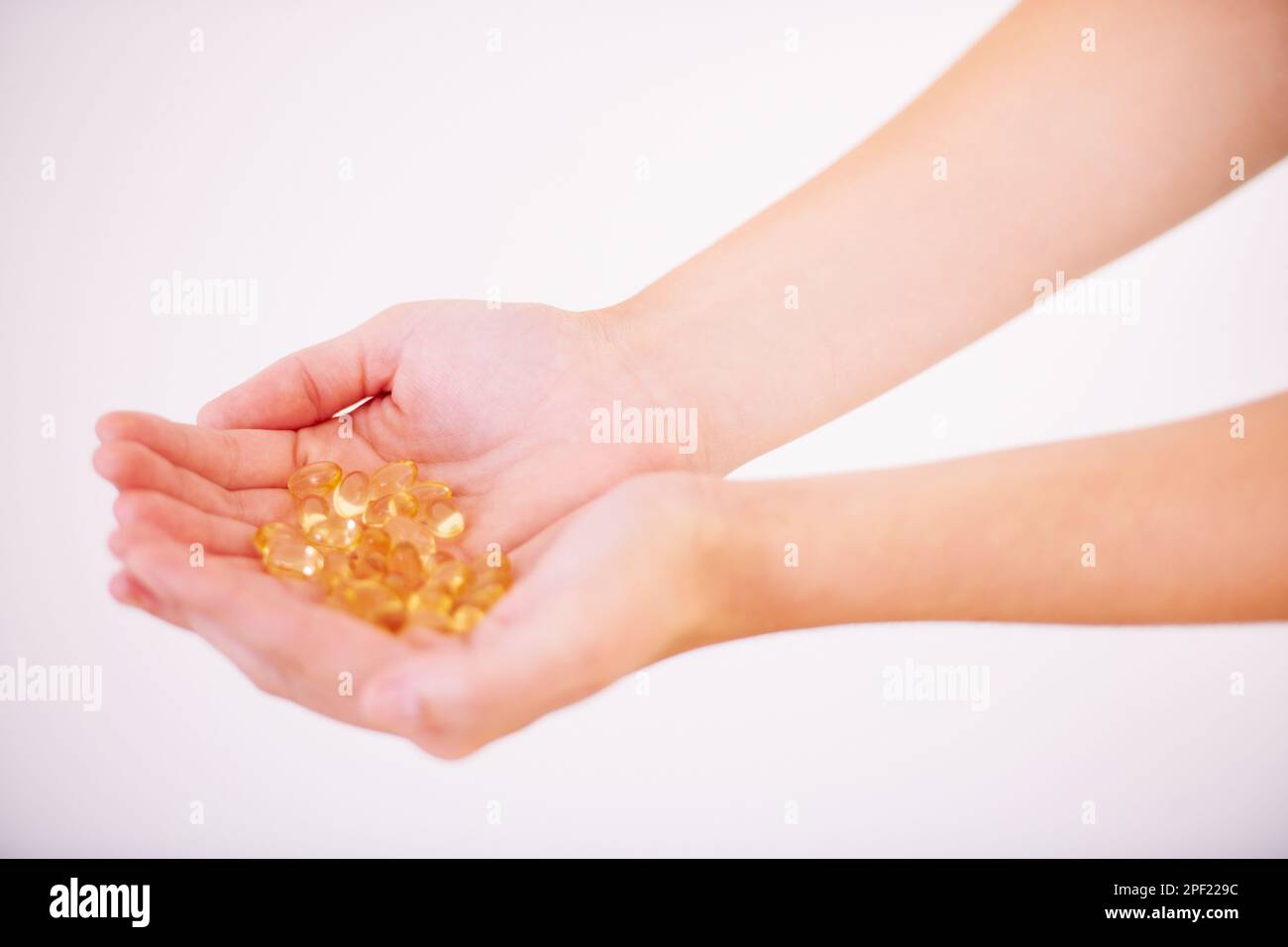 Alles, was der Körper braucht... abgeschnittenes Bild einer Frau, die einen Haufen Vitamine in der Hand hält. Stockfoto