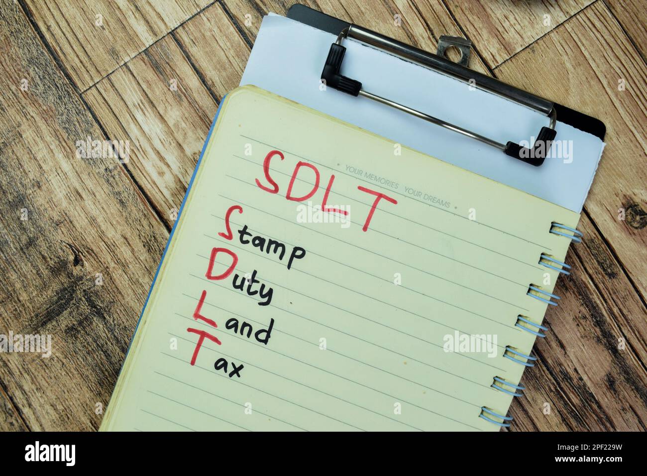 Konzept der SDLT - Stempelgebühr Grundsteuer auf Buch isoliert auf Holztisch schreiben. Stockfoto