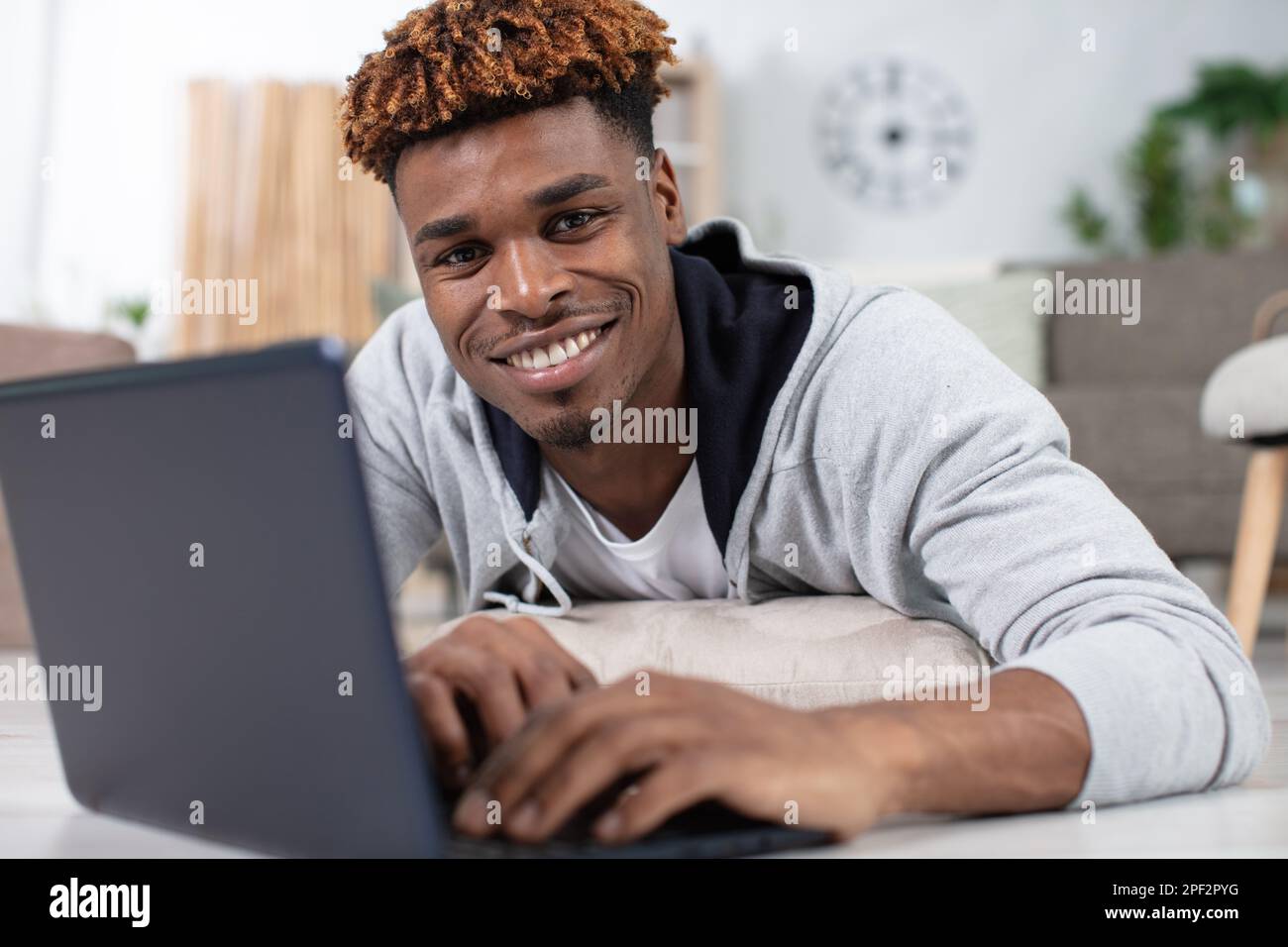 Ein hübscher junger Mann, der lächelnd im Internet surft Stockfoto