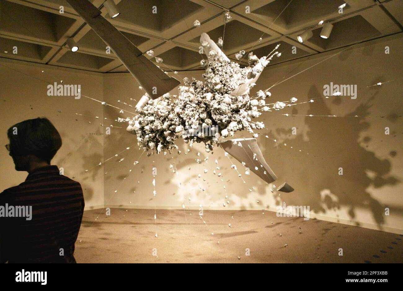 ** ADVANCE FOR WEEKEND EDITIONS NOV. 15-16 ** Huston Paschal, a curator at the North Carolina Museum of Art, is silhouetted in front of a sculpture titled "Exploding Plane" by New York artist Heide Fasnacht, Thursday, Oct. 30, 2003, at the museum in Raleigh, N.C. The sculpture is part of the museum's Defying Gravity exhibition. (AP Photo/Bob Jordan) Stockfoto