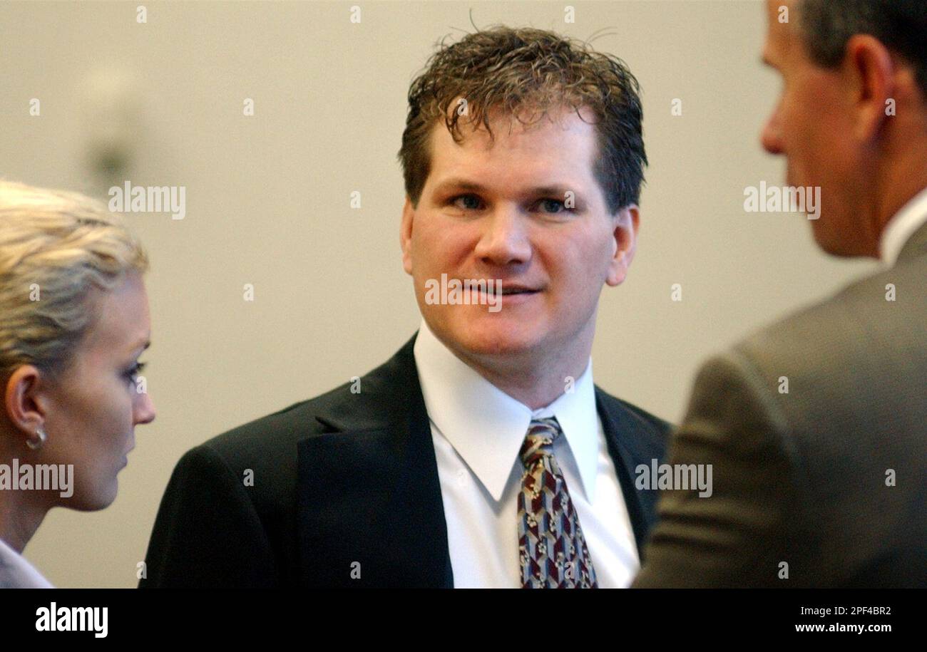 Robert Steven Hatch, center, talks with members of his defense team during his murder trial in a