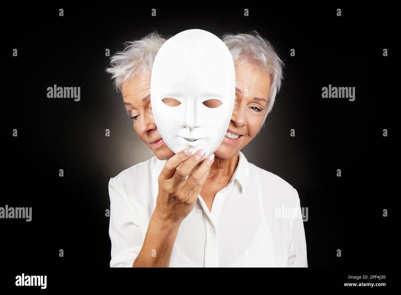 Ältere Frau versteckt sich glücklich und traurig Gesicht hinter der Maske, Konzept für manische Depression oder bipolar oder Fantasy drama Komödie Stockfoto