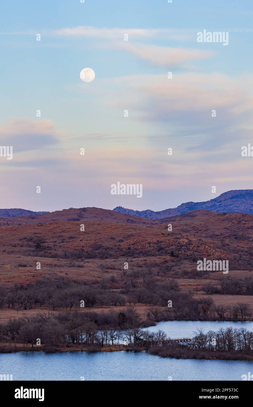 Sonnenuntergang bei Vollmond im Wichita Mountains National Wildlife Refuge in Oklahoma Stockfoto