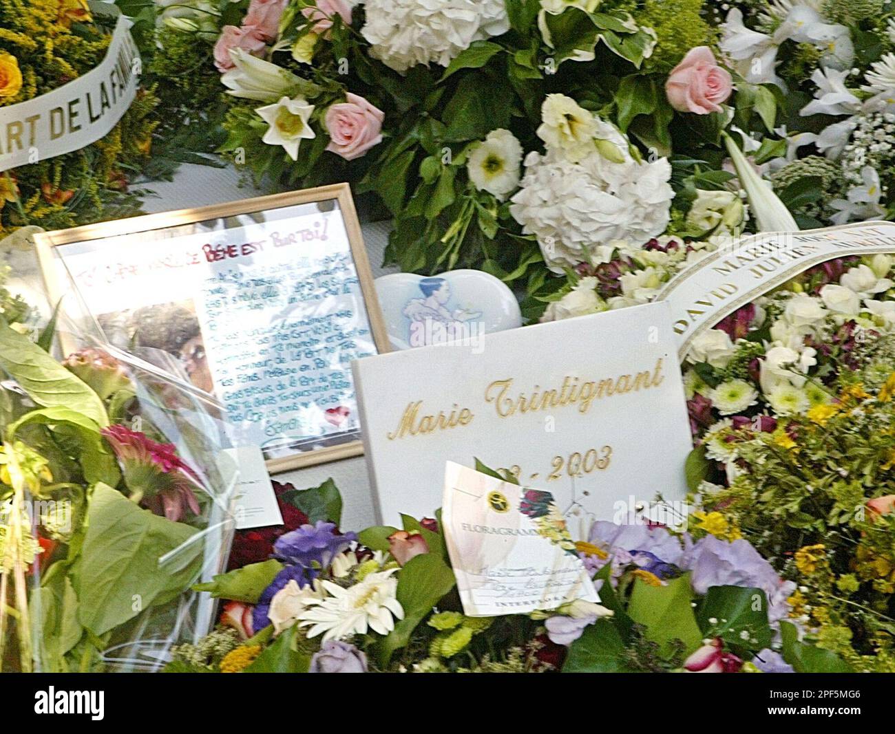 Flowers adorn the gravesite of French actress Marie Trintignant during her funeral at the Pere Lachaise cemetery, in Paris, Wednesday Aug. 6, 2003. Trintignant died on Aug. 1 of a cerebral edema after being beaten. Her boyfriend, French rock star Bertrand Cantat, is the prime suspect. (AP Photo/Amel Pain) Stockfoto
