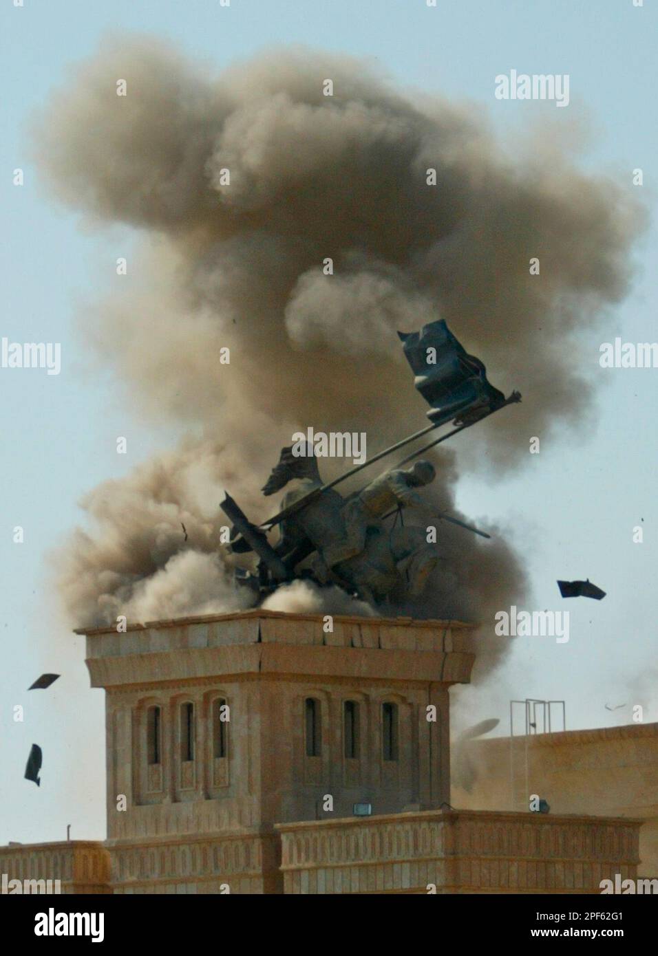 A 30-foot statue of Saddam Hussein on horseback is seen as it is toppled by plastic explosives in Tikrit, 180 km (110 miles) northwest of Baghdad, Iraq, Friday July 18, 2003. (AP Photo/Saurabh Das) Stockfoto