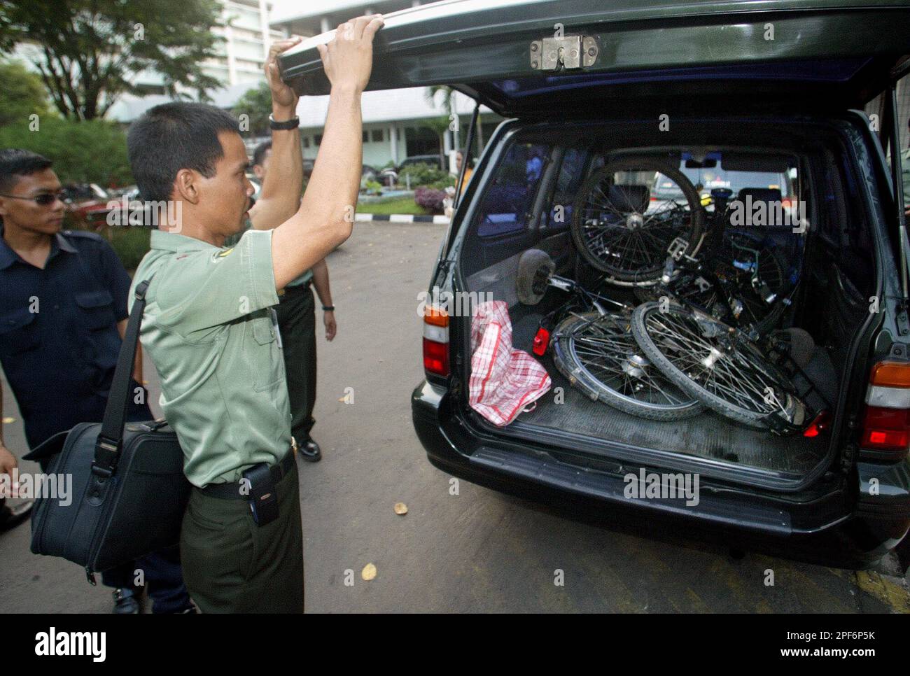 An Indonesian soldier inspects two bicycles belonging to Elisabeth and Lothar Heinrich Albert Engel at Jakarta's main military hospital, Friday, June 6, 2003, in Jakarta, Indonesia. The Engels, a couple from Germany, were in war-torn Aceh as tourists and planning to sleep on a beach when Indonesian troops shot and killed Lothar and wounded Elisabeth, the military said Friday. (AP Photo/Dita Alangkara) Stockfoto