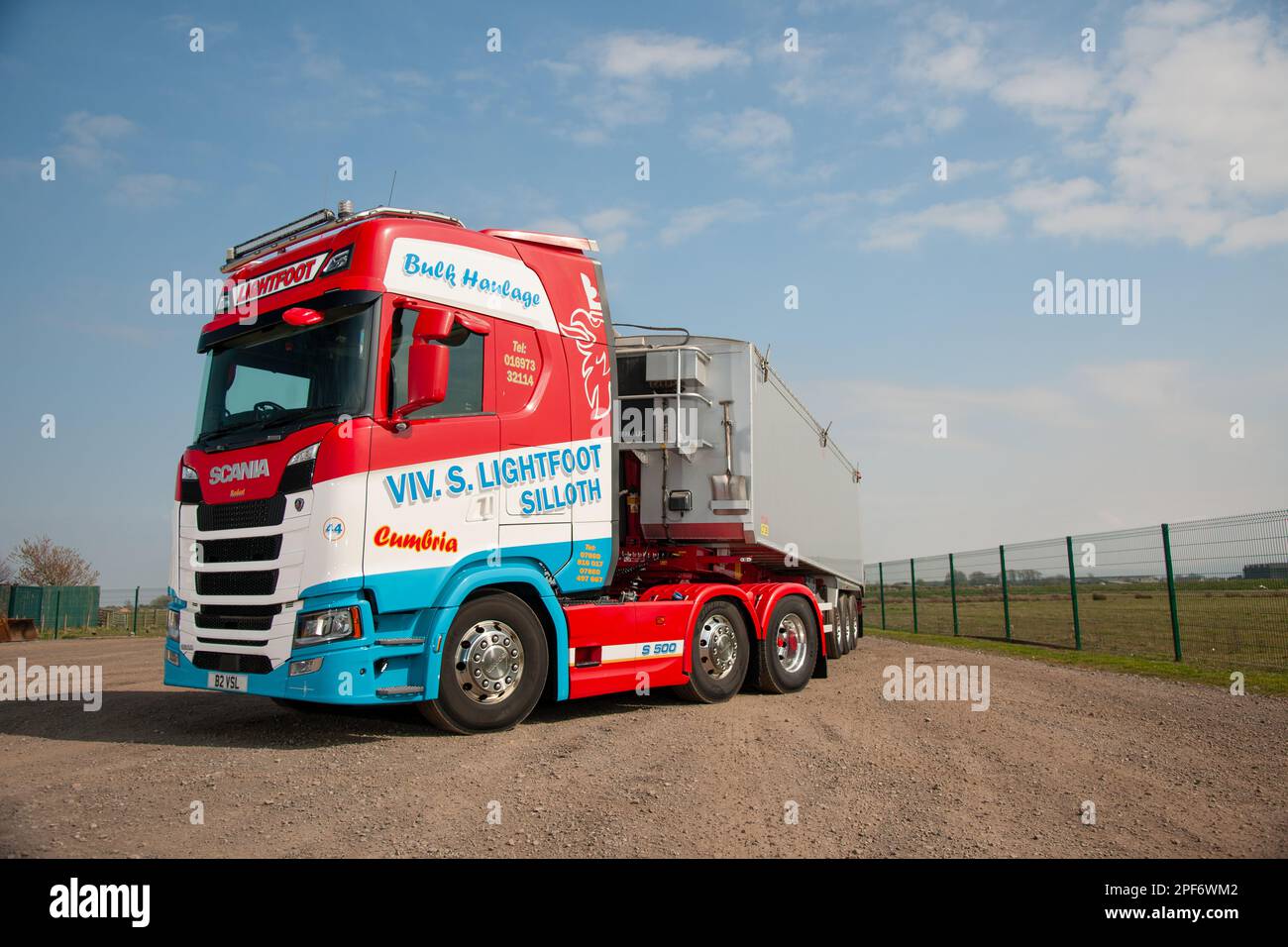 Leichte Transportfahrzeuge Scania Zugmaschine und Fruehauf Kipperwagen für Großtransporte, die an einem sonnigen Tag am Standort des Unternehmens in der Nähe von Silloth, Cumbria, Großbritannien, geparkt sind Stockfoto
