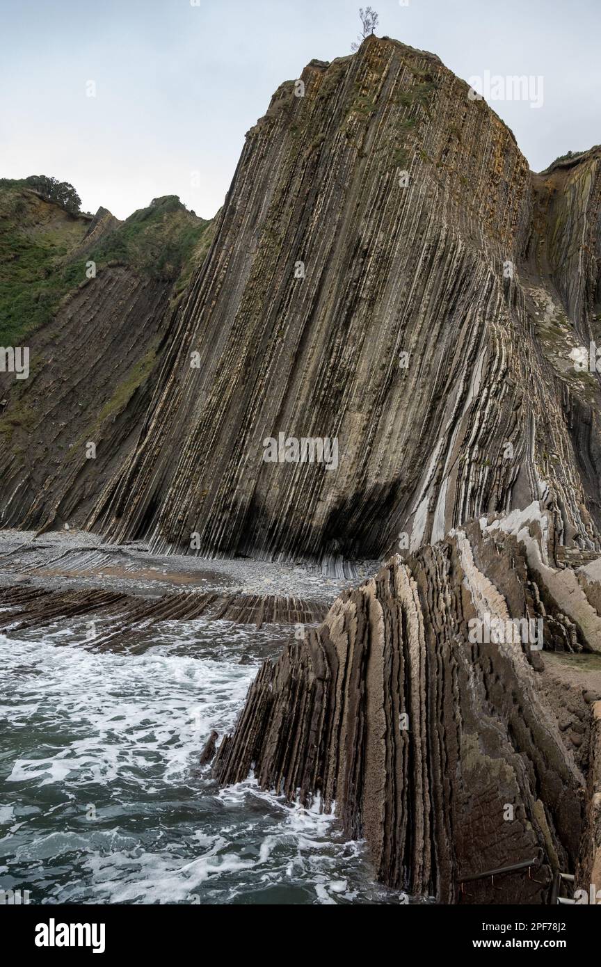 Blick auf steil geneigte Schichten von Flysch-geologischer Formation an der Atlantikküste bei Zumaia bei Ebbe, Baskenland, Spanien Stockfoto