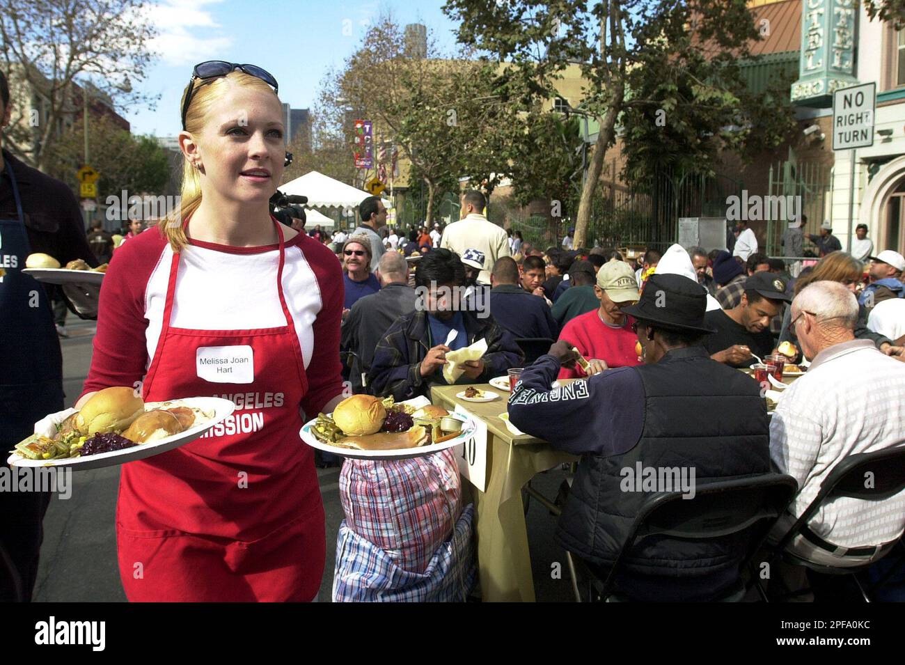 Actress Melissa Joan Hart serves plates of food as celebrities volunteered to serve Thanksgiving meals a day early for hundreds of homeless men and women, Wednesday, Nov. 27, 2002, at the Los Angeles Mission in downtown Los Angeles. (AP Photo/Nick Ut) Stockfoto