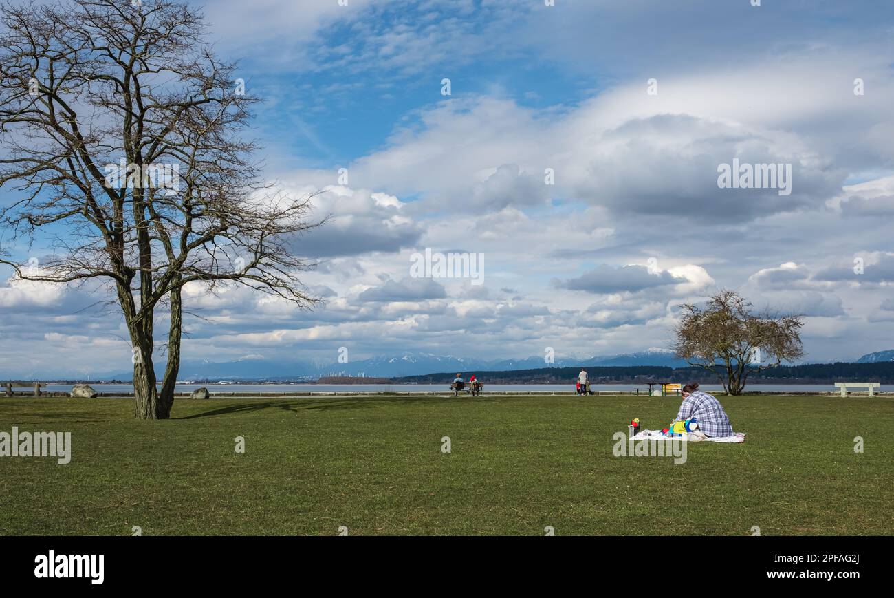 Öffentlicher Park, in dem sich die Leute ausruhen. Frühling im Park. Die Leute entspannen sich. Eine glückliche Familie genießt die Zeit draußen. Zusammensein, Liebe, Glück. Stockfoto