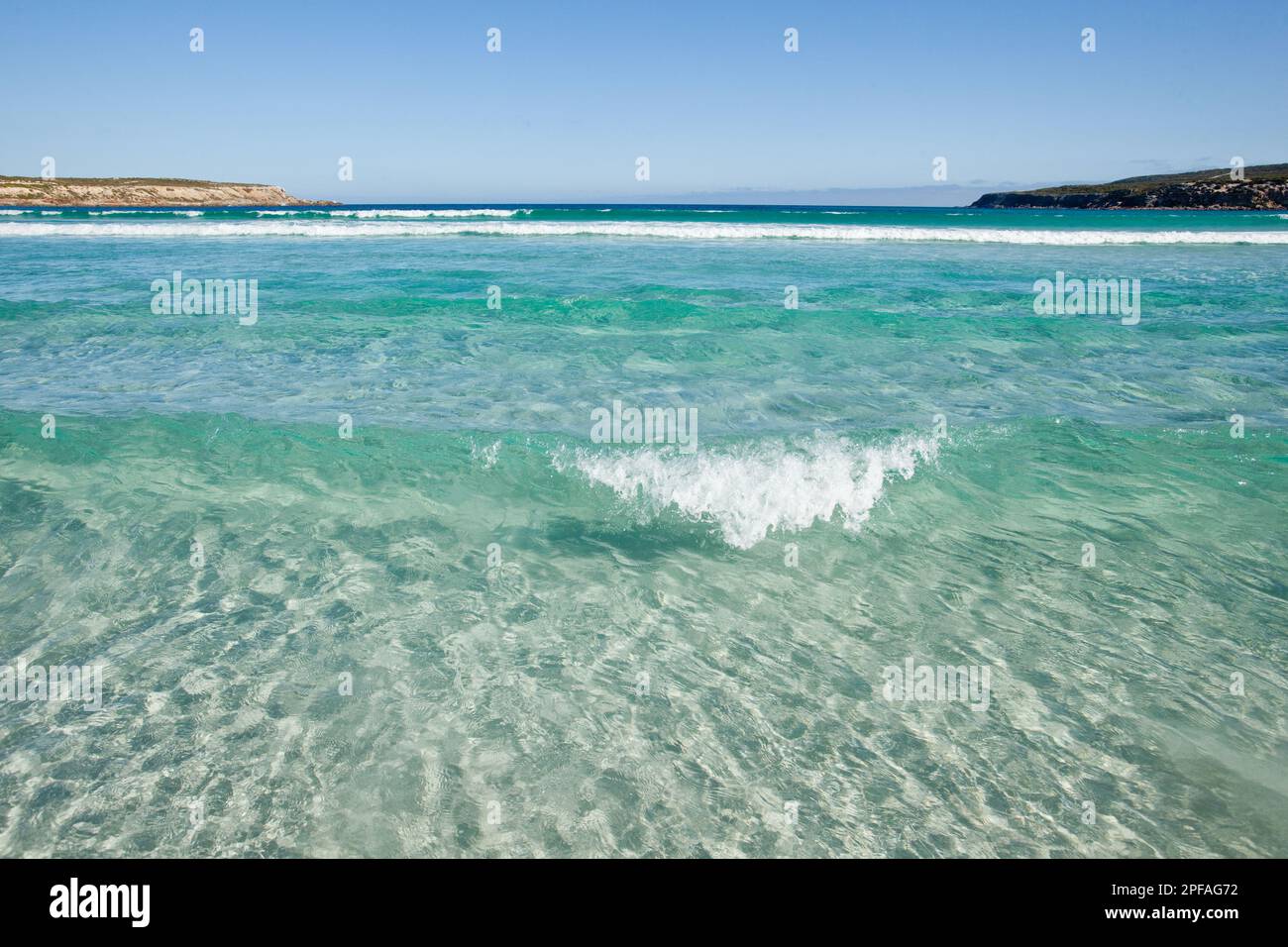 Sauberes klares Wasser mit einer kleinen Welle, die in Fishery Bay South Australia aufbrach. Stockfoto