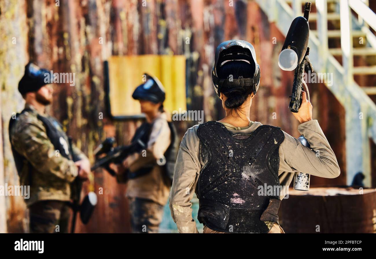 Paintball, Rückansicht oder Frau mit Pistole im Spiel oder Wettkampf für Fitness, Training oder Kardio-Workout. Kriegssoldat, Herausforderung oder weibliche Kriegerin Stockfoto