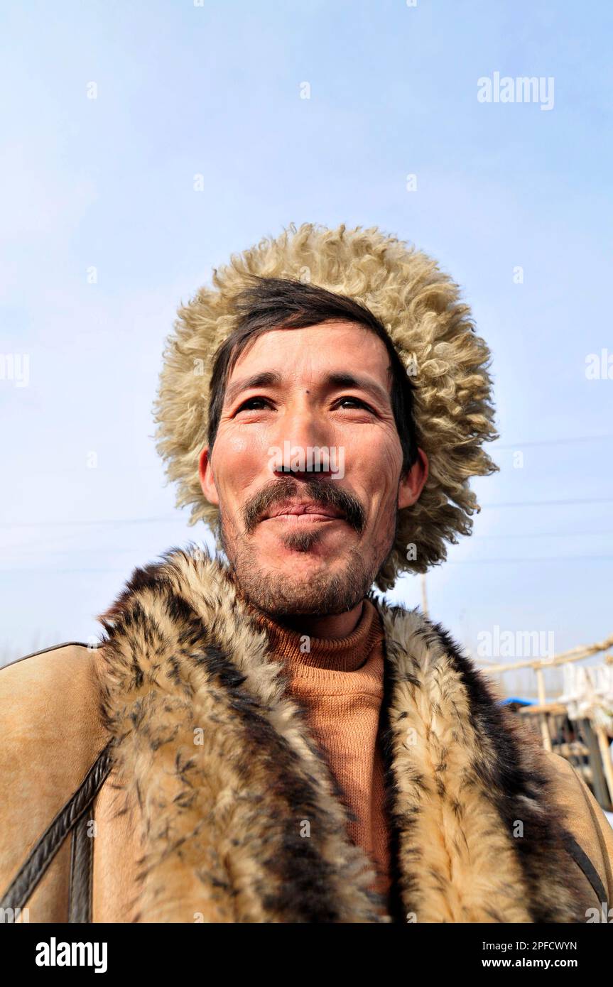 Porträt eines uigurischen Mannes mit Winterjacke. Foto auf einem Wochenmarkt in den Außenbezirken von Kashgar, Xinjiang, China. Stockfoto