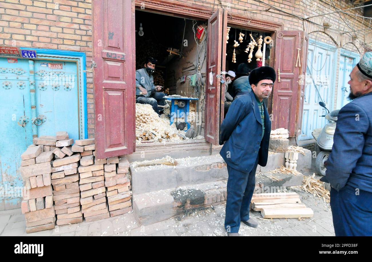 Uiguren stehen vor einer Werkstatt in der Altstadt von Kashgar, Xinjiang, China. Stockfoto
