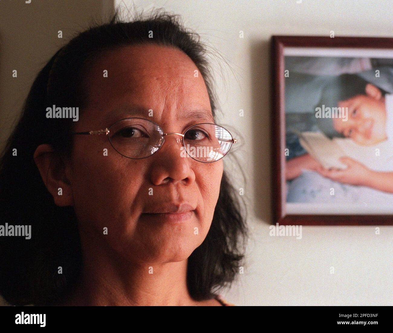 ADVANCE FOR FRIDAY, JUNE 11--Andy Sombillo, a live-in Philippine nanny, poses near a photograph of her 11-year-old son Neil Patrick Sombillo on Sunday, June 6, 1999, in New York. In 1997 Sombillo started the group PAWID, Pinyas (Filipinas) in America Working in Domestic Settings, to offer women legal advice, help with immigration matters and other services. (AP Photo/Daine Bondareff) Stockfoto