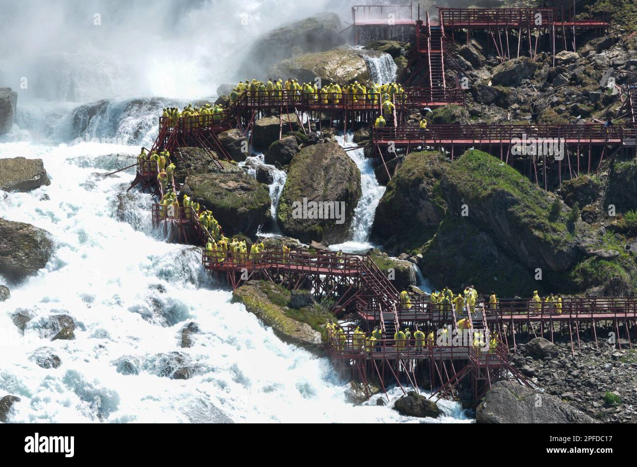 Niagara Falls Town, ON, Kanada - 30. Mai 2015: Gruppe von Touristen in gelben Regenmänteln, die die Niagarafälle beobachten und Fotos machen Stockfoto