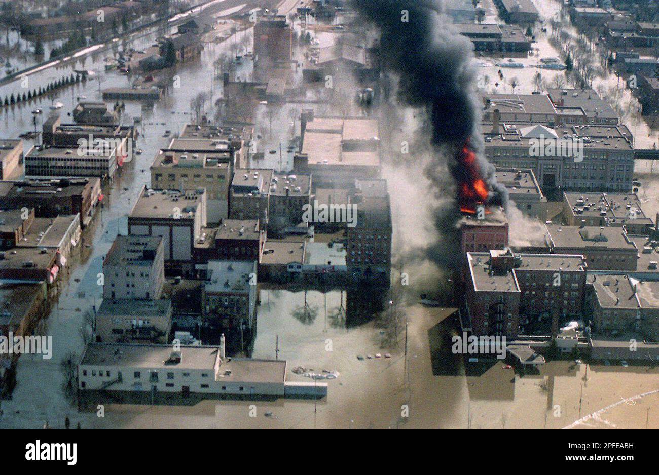 Smoke and flames rise from the Security Building Saturday, April 19, 1997,in Grand Forks, N.D. just hours after the rampaging Red River flooded the downtown area. Record floods have forced the evacuation of many of the city's 50,000 residents. Firefighters were unable to battle the blaze due to flooded streets. AP Photo/St. Paul Pioneer Press, John Doman) Stockfoto