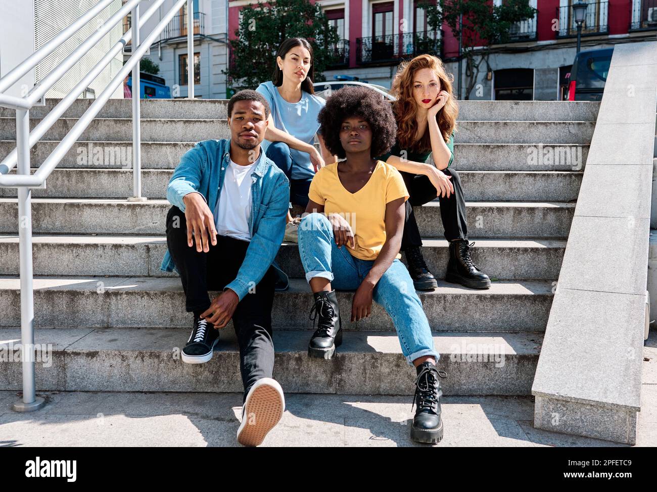 Multiethnische Gruppe von Freunden, die auf der urbanen Treppe sitzen Stockfoto