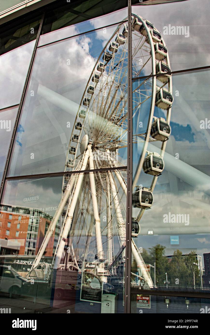 Riesenradreflexion in Glasfassade an den Liverpool Docks--das Riesenrad von Liverpool. Stockfoto