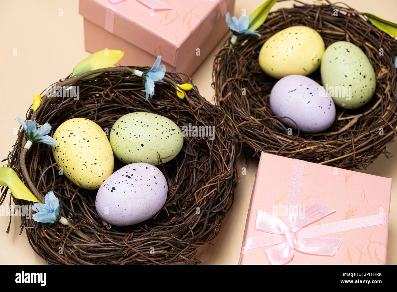 Geschenke zu Ostern, Osterverkauf. Eier in Nestern und Geschenkschachteln auf beigefarbenem Hintergrund Stockfoto
