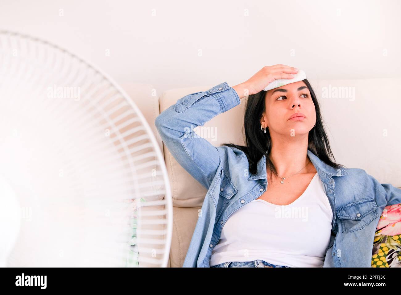 Frau, die unter Sommerhitze leidet und versucht, während der Hitzewelle kühl und bequem zu bleiben Stockfoto