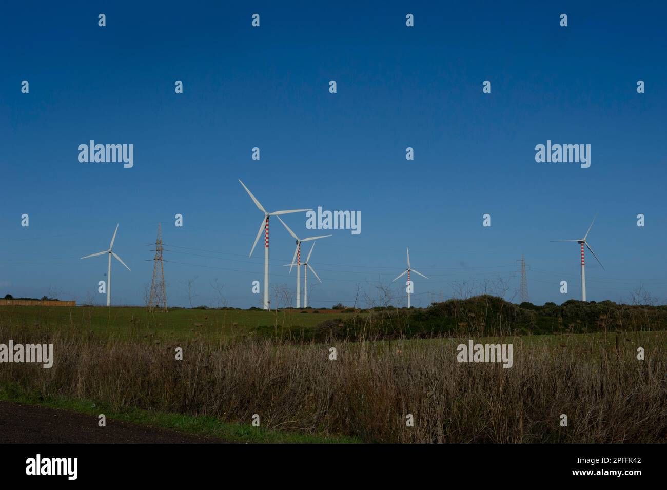 2022. April 26 Italien, Europa. Windturbine zur Stromerzeugung mit Blick auf die Landschaft und klarem Himmel, erneuerbare Energien, Fiumesanto Park in Porto Torres. Stockfoto