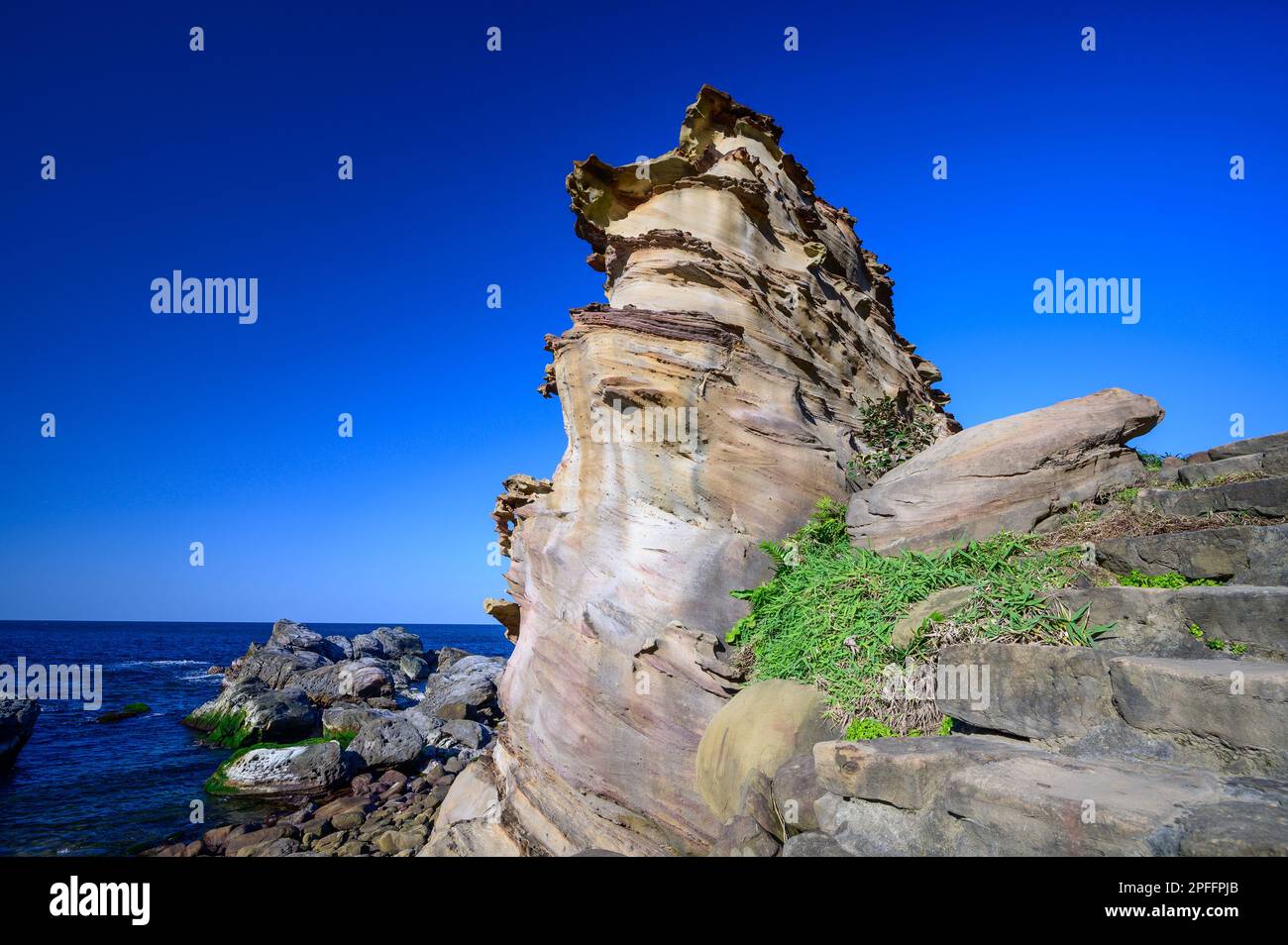 Die Struktur der Felsoberfläche ähnelt den Wachstumsringen eines Baumes. Blauer Himmel. Die eigenartige felsige Landschaft von Ruifang Nanya, New Taipei City. Taiwan Stockfoto