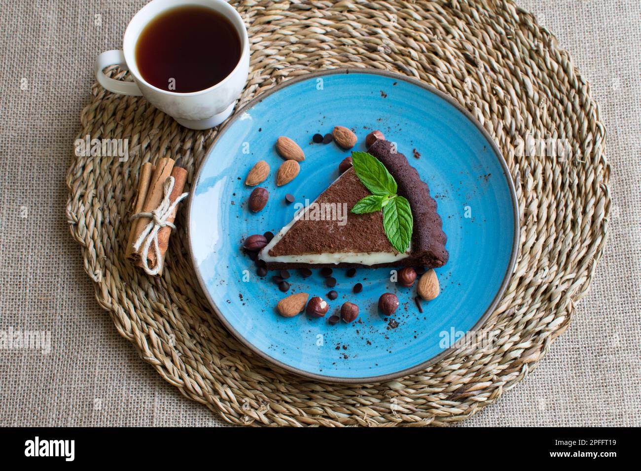 Gebäckcreme und Tee auf Kakaokuchen, Blick von oben. Stockfoto