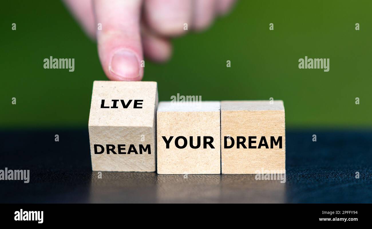 Die Hand dreht den hölzernen Würfel und ändert den Ausdruck „Träum deinen Traum“ in „lebe deinen Traum“. Stockfoto