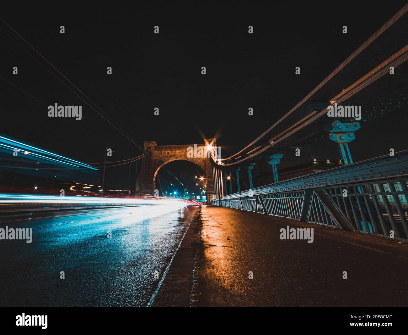 Brücke bei Nacht mit Fahrzeugen und leichten Wanderwegen Stockfoto