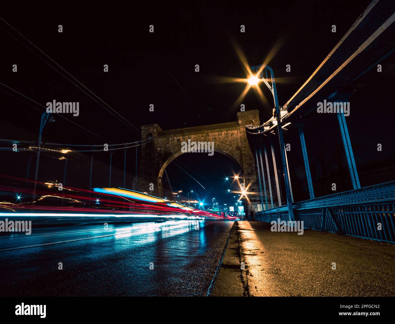 Brücke bei Nacht mit Fahrzeugen und leichten Wanderwegen Stockfoto