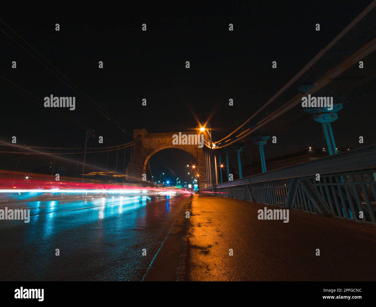 Brücke bei Nacht mit Fahrzeugen und leichten Wanderwegen Stockfoto