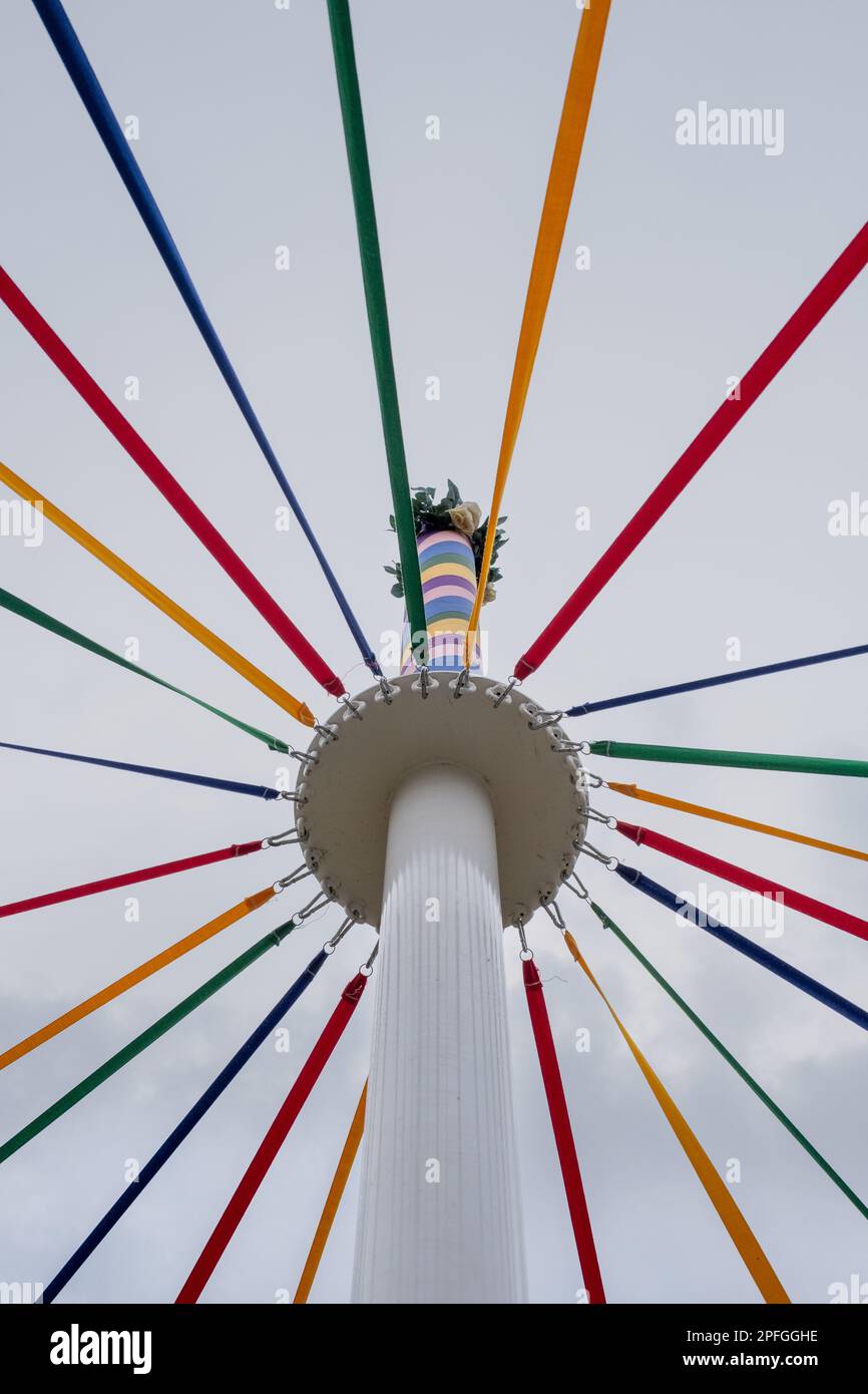 Ein kleiner Winkel eines klassischen englischen Maypole während eines Tanzfestivals unter bewölktem Himmel Stockfoto