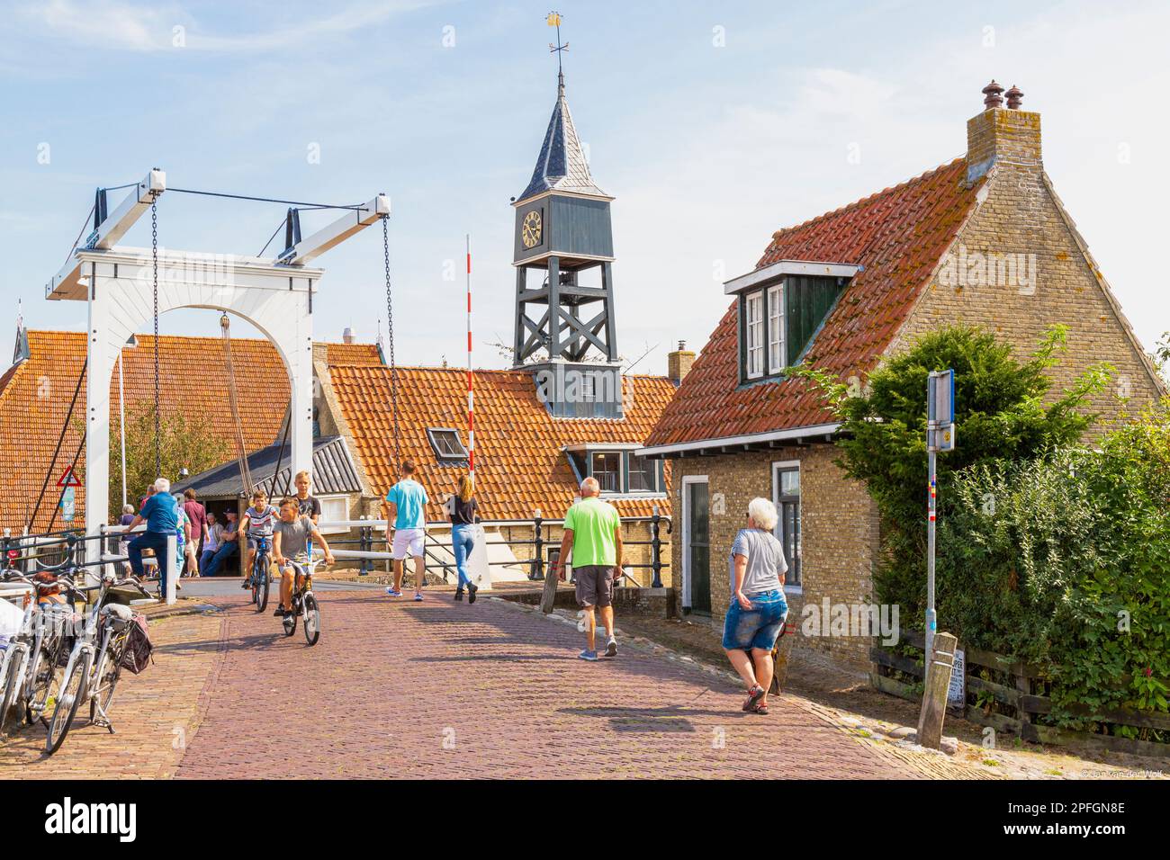 Einwohner und Touristen spazieren auf dem Deich der Stadt Hindeloopen in Friesland. Stockfoto