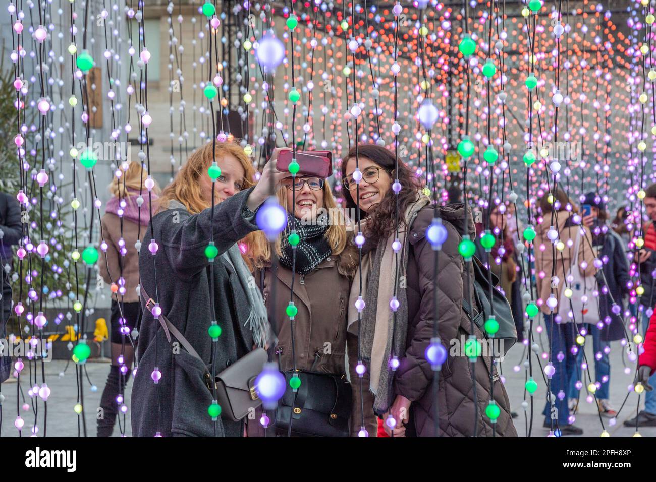 Lichtspiele im Mont-des Arts in Brüssel anlässlich der Lichterkundungen zum Jahresende. Drei Frauen machen ein Selfie. Stockfoto