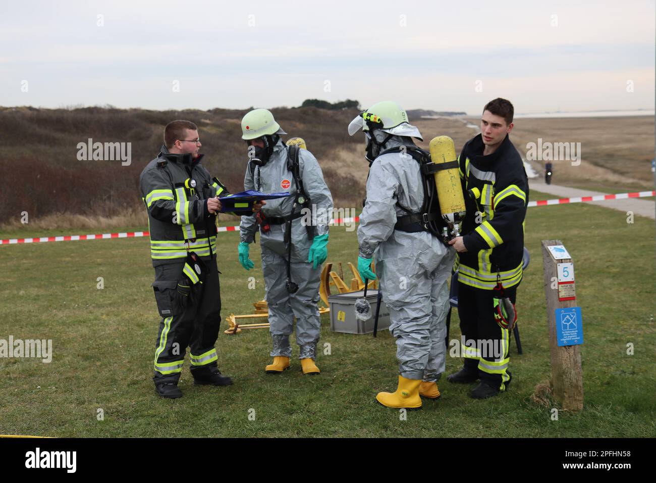 Wangerooge, Deutschland. 17. März 2023. Notfallpersonal in Schutzanzügen und Feuerwehrleute bereiten sich während einer größeren Übung des Notfallteams am nordöstlichen Strand der Insel Wangerooge vor. Während der Übung üben rund 130 Notfallpersonal Schutzmaßnahmen im Falle eines Chemieunfalls durch ein Schiffswrack aus. (Zu dpa: "Was tun bei einem Chemieunfall? Über 100 Forces Practice on Wangerooge') Kredit: Peter Kuchenbuch-Hanken/dpa/Alamy Live News Stockfoto