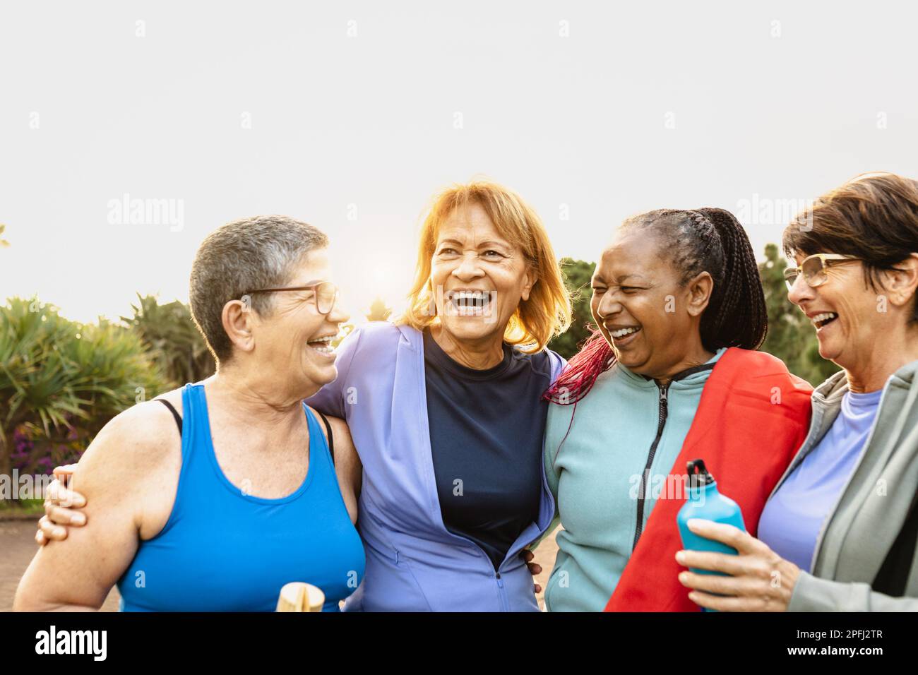 Fröhliche, multiethnische Seniorinnen, die nach dem Training im Park Spaß haben Stockfoto