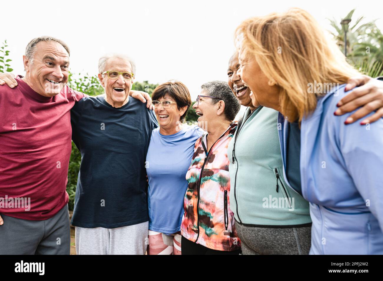 Eine Gruppe verschiedener Senior-Freunde, die nach dem Training im Park Spaß haben Stockfoto